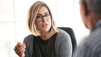 Female teacher in discussion with male colleague.
