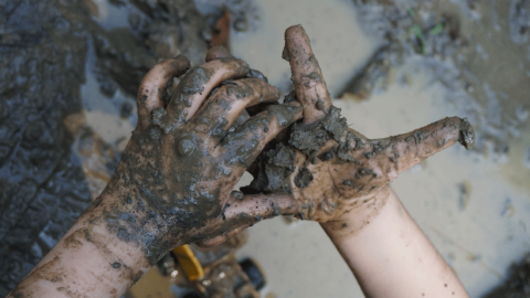 Close-up of child's muddy hands