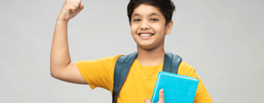Happy school boy wearing yellow t-shirt flexing arm